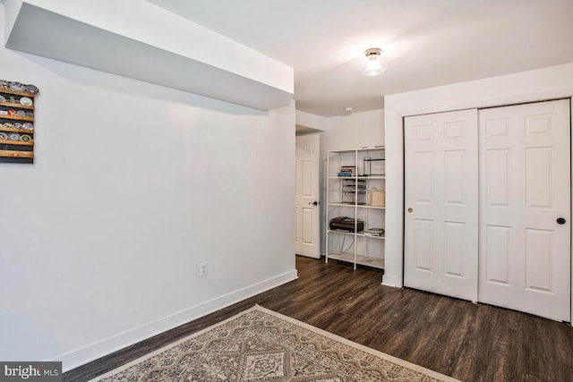 bedroom featuring wood finished floors, baseboards, and a closet