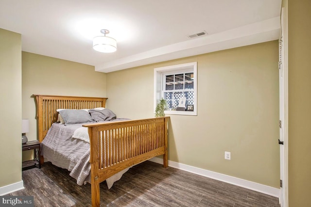 bedroom featuring visible vents, baseboards, and wood finished floors