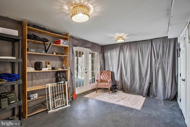 living area featuring french doors and concrete flooring