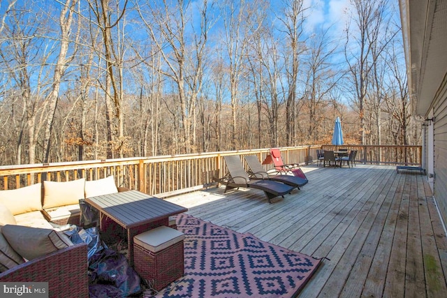 deck featuring outdoor lounge area and a forest view