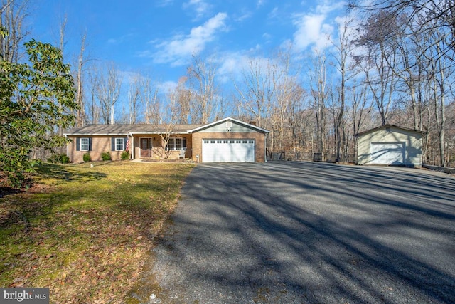 single story home with brick siding, an attached garage, aphalt driveway, and a front lawn