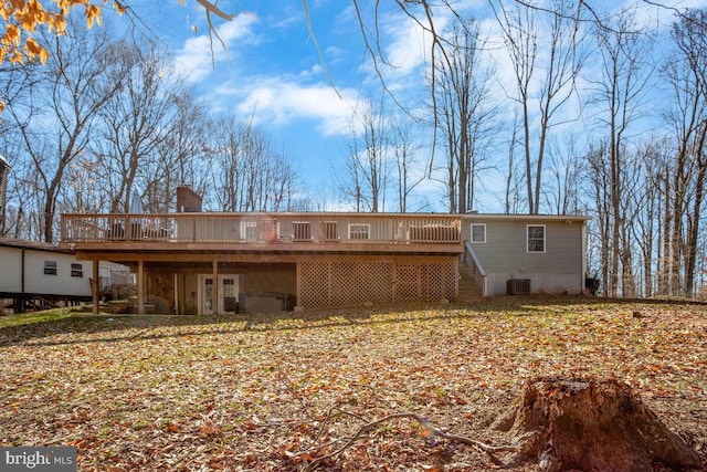 rear view of property featuring stairs, a wooden deck, and a chimney