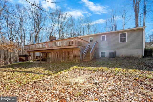 rear view of property with cooling unit, a chimney, stairs, and a deck