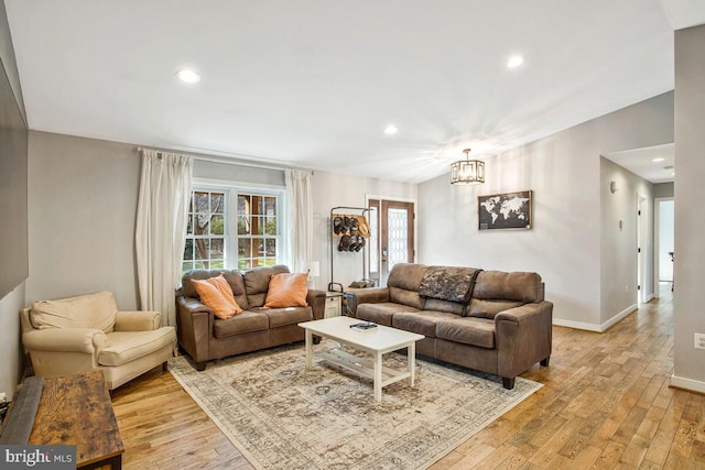 living room with recessed lighting, light wood-style flooring, baseboards, and vaulted ceiling