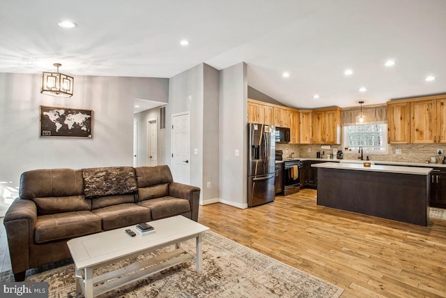 living area featuring recessed lighting, light wood-type flooring, baseboards, and vaulted ceiling