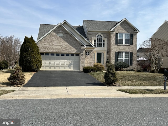 traditional-style house featuring aphalt driveway, brick siding, roof with shingles, and an attached garage