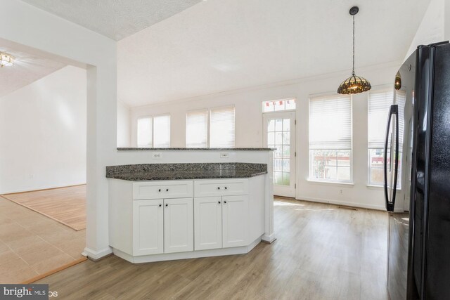 kitchen featuring baseboards, freestanding refrigerator, light wood-style flooring, and white cabinetry