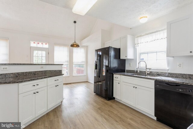 kitchen featuring white cabinets, a sink, light wood-style floors, vaulted ceiling, and black appliances