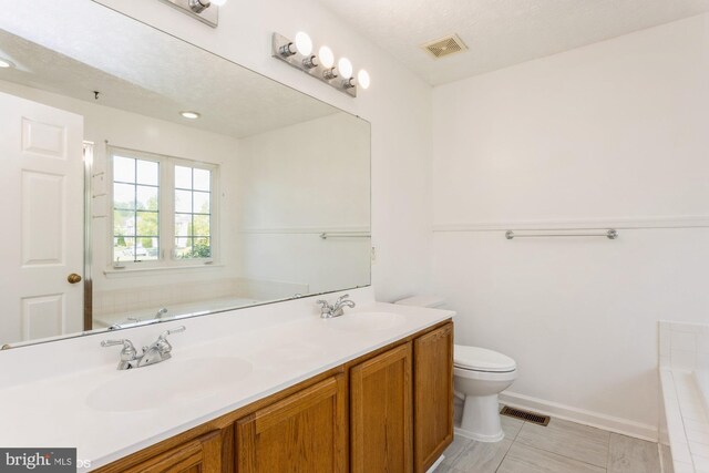 full bath featuring a sink, a garden tub, and visible vents