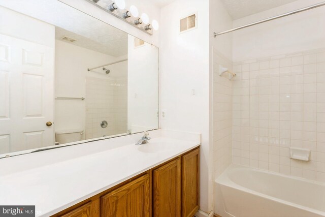 bathroom featuring vanity, washtub / shower combination, visible vents, and toilet