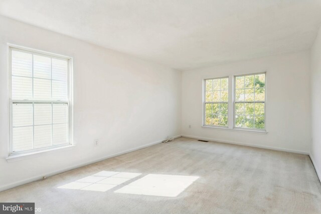 carpeted empty room featuring baseboards