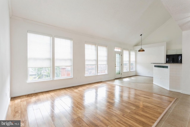unfurnished living room with visible vents, ornamental molding, baseboards, high vaulted ceiling, and light wood-type flooring