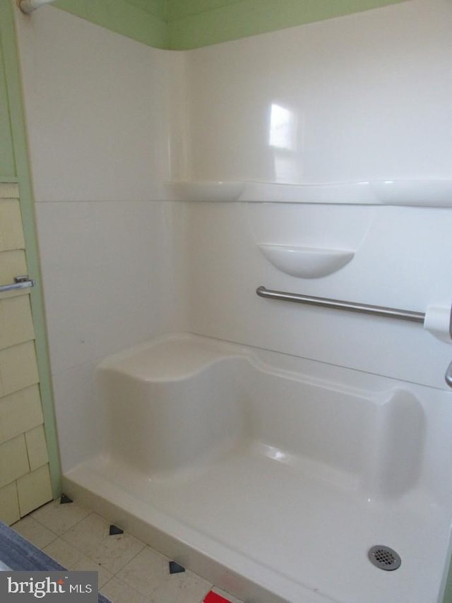 full bathroom featuring tile patterned flooring and a stall shower