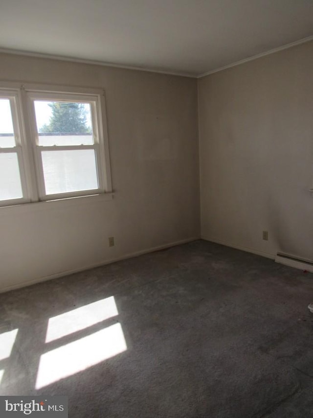 empty room featuring a baseboard heating unit, carpet, and ornamental molding