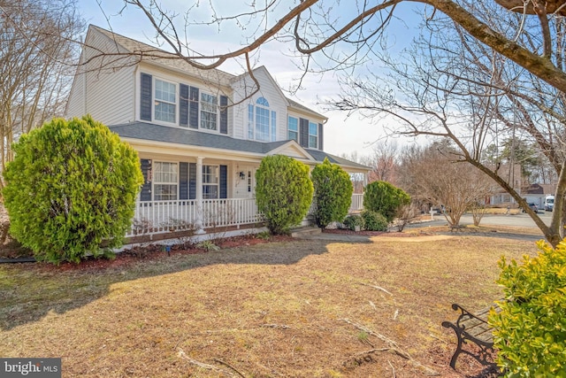 view of front of property featuring a porch, a front lawn, and a shingled roof