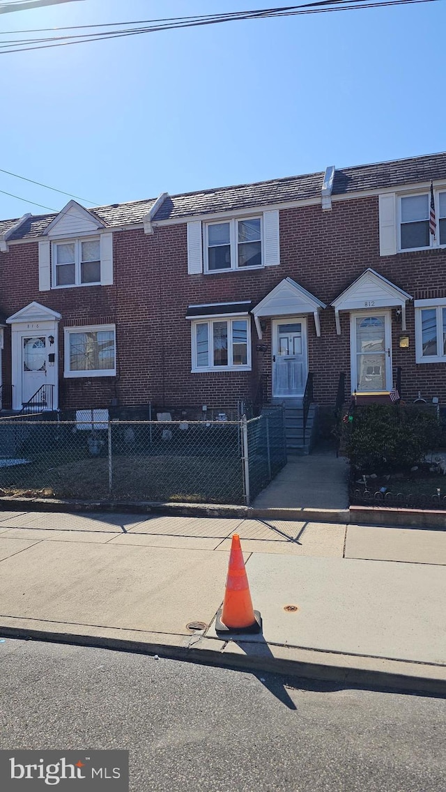 view of property featuring a fenced front yard and brick siding