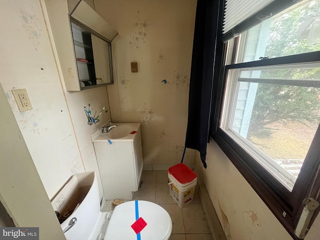 bathroom featuring tile patterned floors, baseboards, toilet, and vanity