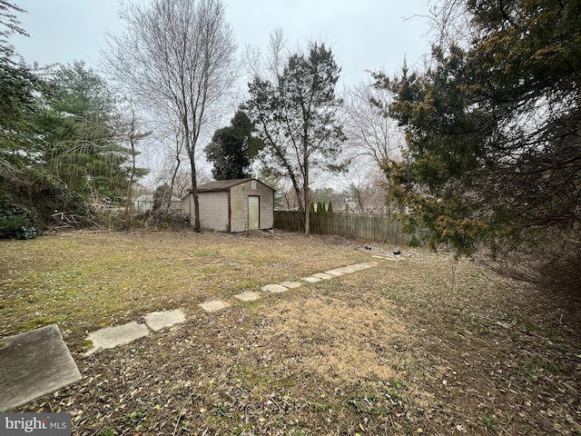 view of yard featuring an outbuilding, a shed, and fence