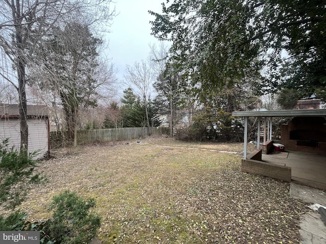 view of yard with an outbuilding, a patio area, and fence