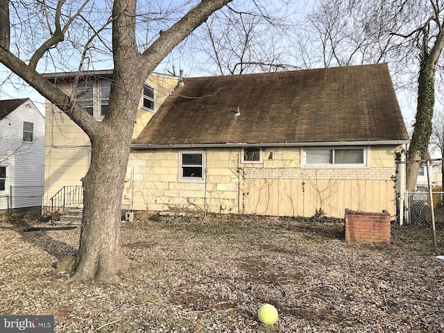 back of property featuring fence and roof with shingles