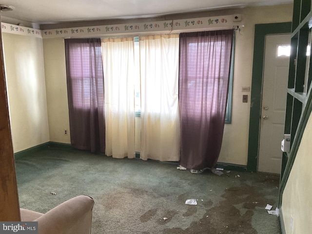 spare room featuring carpet flooring and baseboards