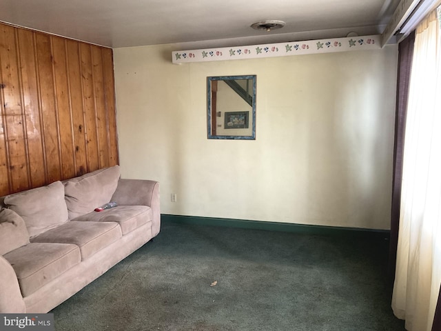 unfurnished living room featuring wood walls and carpet floors