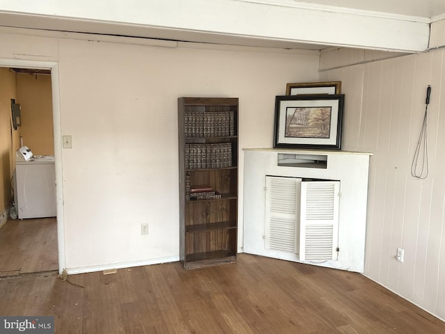 interior space featuring washer and dryer, wood finished floors, and wood walls