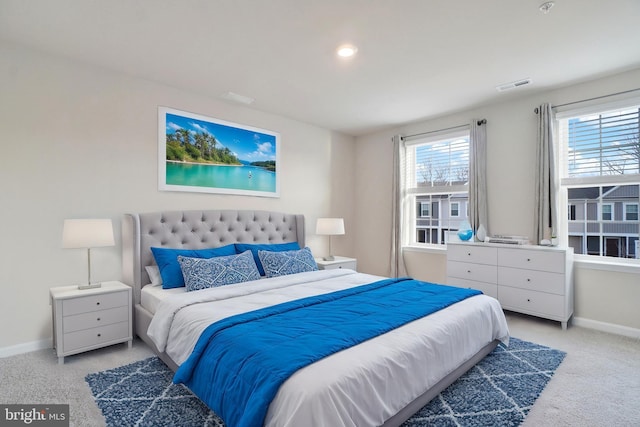 bedroom with visible vents, baseboards, and light colored carpet