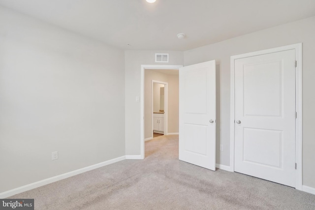 unfurnished bedroom with visible vents, baseboards, and light colored carpet