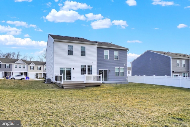 rear view of house with fence, a yard, a deck, central air condition unit, and a residential view