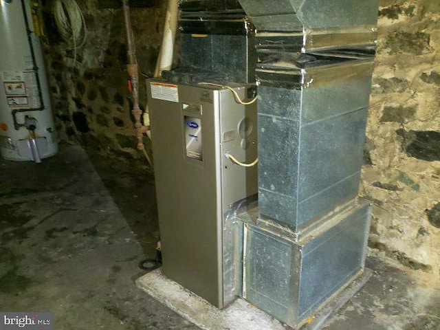 utility room with heating unit and water heater