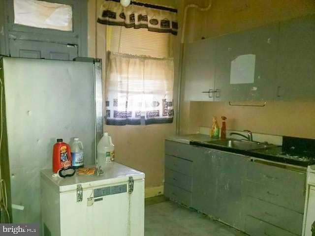 kitchen featuring a sink and freestanding refrigerator