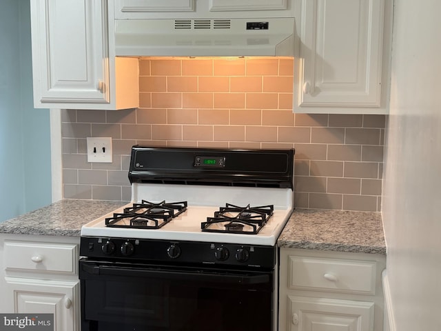 kitchen featuring gas stove, tasteful backsplash, under cabinet range hood, and white cabinets