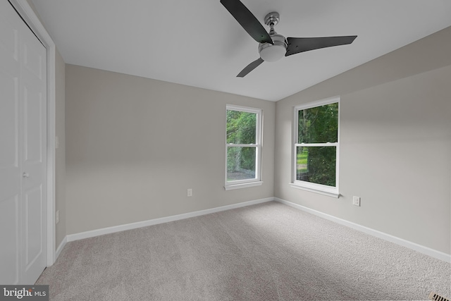 empty room with baseboards, carpet floors, a ceiling fan, and vaulted ceiling