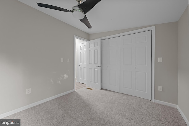 unfurnished bedroom featuring a ceiling fan, carpet, baseboards, and a closet