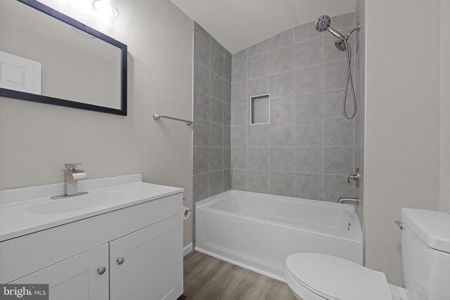 bathroom featuring bathtub / shower combination, vanity, toilet, and wood finished floors