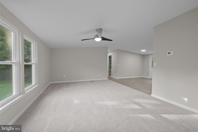 unfurnished room with a wealth of natural light, baseboards, ceiling fan, and carpet flooring