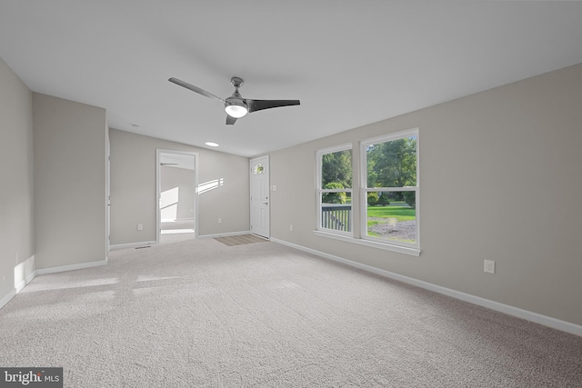 spare room featuring a ceiling fan, carpet, and baseboards