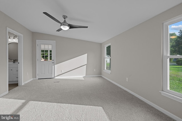 carpeted spare room with baseboards and plenty of natural light