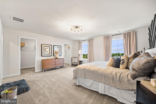 carpeted bedroom with a spacious closet, baseboards, visible vents, and a closet