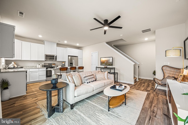 living area with visible vents, recessed lighting, stairway, and wood finished floors