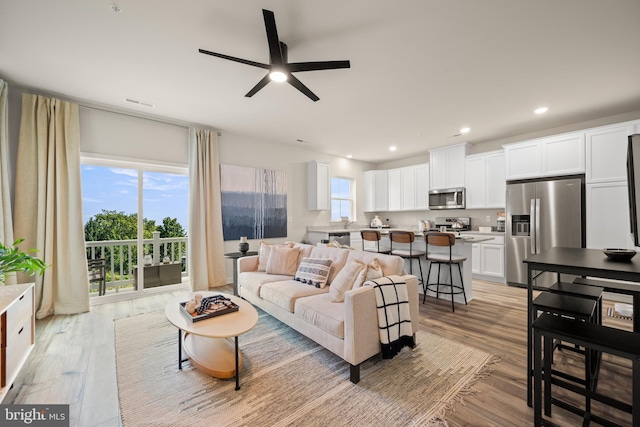 living room with recessed lighting, visible vents, light wood finished floors, and ceiling fan