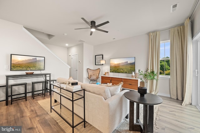 living area with visible vents, light wood-style flooring, and a ceiling fan