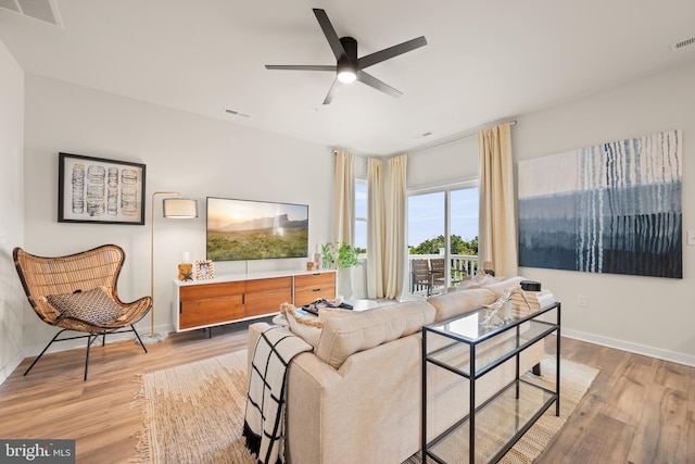 living room featuring wood finished floors, visible vents, and baseboards