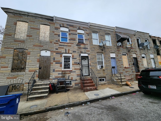 view of property with stone siding, cooling unit, and entry steps