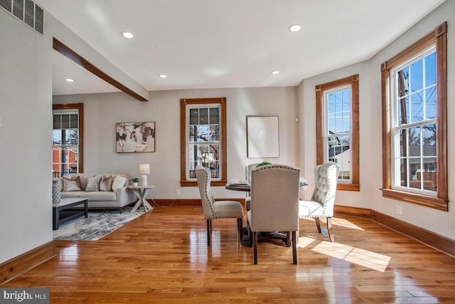 dining area with light wood-style flooring, baseboards, and visible vents