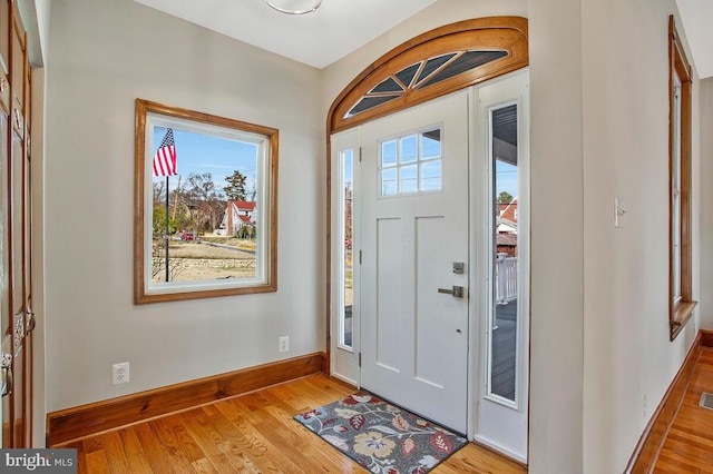 foyer entrance with visible vents, light wood-style flooring, and baseboards