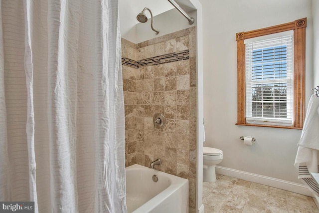 bathroom with shower / tub combo, toilet, and baseboards