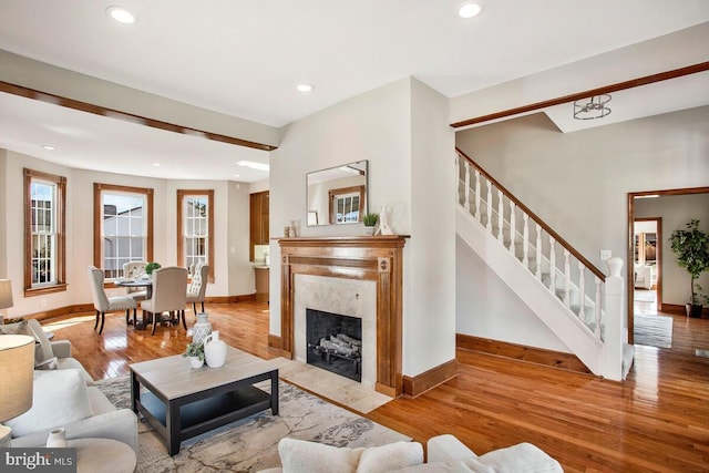 living area featuring stairway, recessed lighting, baseboards, and wood finished floors