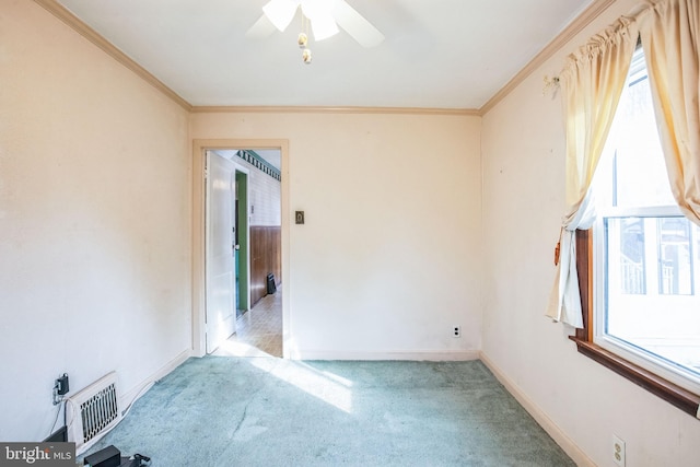 empty room with ceiling fan, carpet flooring, visible vents, and ornamental molding